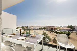 a table and chairs on a balcony with a view at Sunny Apartments in Cabanas de Tavira