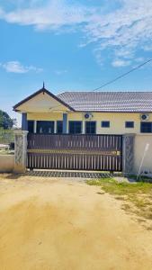a house with a wooden fence in front of it at Rhuteng Homestay in Setiu