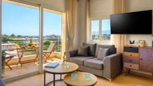 a living room with a couch and a large window at Ormos senses in Agios Nikolaos