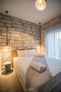 a bedroom with a large bed and a brick wall at Gialos Villas Paleochora in Palaiochóra