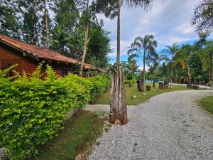 ein Holzzaun auf einer Schotterstraße neben einem Gebäude in der Unterkunft Cabana Vita Bella in Nova Trento