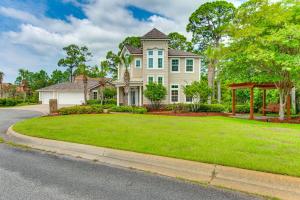 a house with a green lawn in front of it at Steps to Bay Tranquil Navarre Retreat with Balcony in Navarre
