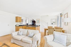 un salon avec deux canapés blancs et une cuisine dans l'établissement Host & Stay - Dove Cottage, à Warkworth 13 autres photos