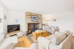 a living room with white furniture and a fireplace at Host & Stay - Dove Cottage in Warkworth +12 photos