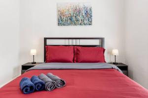 a bedroom with a red bed with towels on it at Adorable Pasadena Bungalow in Pasadena