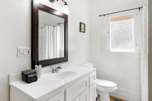 a white bathroom with a sink and a mirror at Adorable Pasadena Bungalow in Pasadena +15 photos