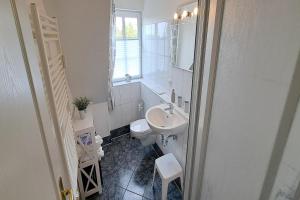 a white bathroom with a sink and a toilet at Ferienwohnung Lachmöwe Dagebüll in Dagebüll