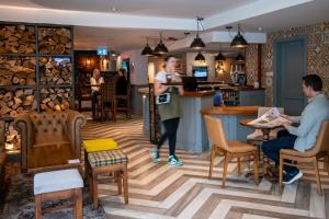 a restaurant with people sitting at a counter and a bar at Lodge at Solent in Fareham