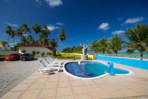uma piscina com espreguiçadeiras e um resort em Pousada Venezia Tropicale em Japaratinga