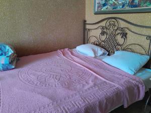 a bed with a purple blanket and pillows at Zatoka in Zatoka