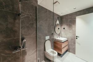 a bathroom with a shower and a toilet and a sink at BW Symphony Suites in Belgrade +30 photos