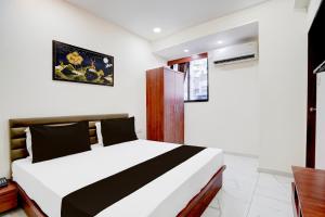 a bedroom with a white and black bed in a room at Hotel O Railway in Vadodara