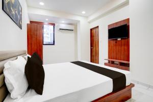 a bedroom with a bed and a flat screen tv at Hotel O Railway in Vadodara