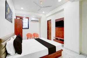 a bedroom with a bed and two chairs at Hotel O Railway in Vadodara