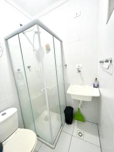 a bathroom with a shower and a toilet and a sink at Linda Kitinete frente a praia in São Vicente