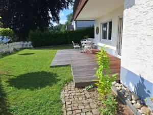 eine Holzterrasse mit einem Tisch und Stühlen im Hof in der Unterkunft Wohnen am Waldrand, zentral und ruhig in Siegen