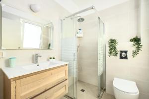 a bathroom with a toilet and a sink and a shower at Sea Breeze Netanya Retreat with Mamad by Sea N' Rent in Netanya +27 photos