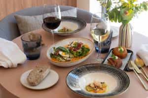 a table with plates of food and glasses of wine at Catalonia Excelsior in Valencia