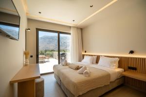 una camera da letto con un letto grande e una grande finestra di Villa Zen Aphrodite by PosarelliVillas a Asprouliánoi Altre 37 foto