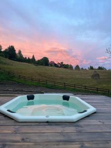 a bath tub sitting on top of a wooden table at Cabana KayLuna in Mătişeşti +48 photos