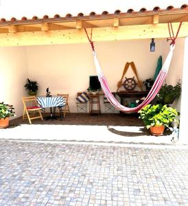 un patio con amaca, tavolo e sedie di CASA DAS MARÉS MILFONTES by Stay in Alentejo a Vila Nova de Milfontes