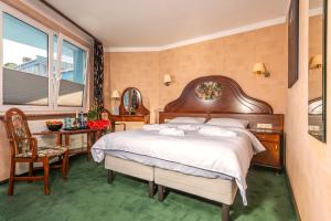 a bedroom with a bed and a table and a window at Apartamenty BLACK PEARL in Kołobrzeg +37 photos