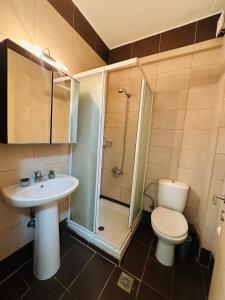 Un baño con inodoro, lavabo y ducha. en A&B Villa Nea Fokea, en Nea Fokea