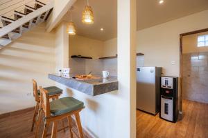 a kitchen with a counter and some chairs and a refrigerator at Cove Lotus Lofts Seminyak in Seminyak +16 photos