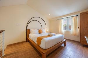 a bedroom with a large bed with a wooden frame at Cove Lotus Lofts Seminyak in Seminyak