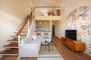 a living room with a couch and a staircase at Cove Lotus Lofts Seminyak in Seminyak