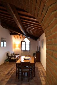 sala de estar con mesa de madera y pared de ladrillo en Tognazzi Casa Vacanze - Appartamento Rebecca, en San Gimignano