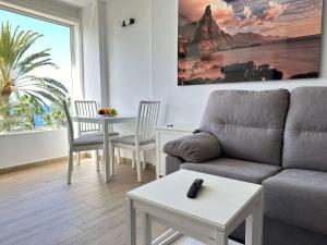 a living room with a couch and a table at Neues Studio direkt am Strand in Arguineguín +39 photos