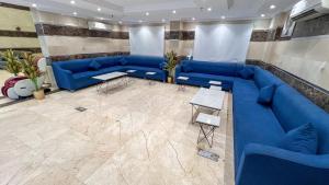 a living room with blue couches and a tile floor at فندق اركان المطاف يوجد لدينا باص للحرم in Mecca