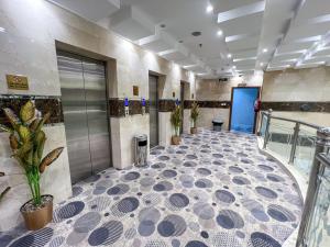 a large lobby with a tile floor and plants at فندق اركان المطاف يوجد لدينا باص للحرم in Mecca