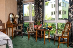 a room with a bed and a table and chairs at Apartamenty BLACK PEARL in Kołobrzeg