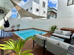 a patio with a swimming pool in a house at Paddington House - private pool & rooftop in Flic-en-Flac