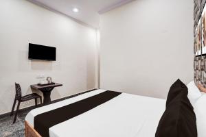 Un dormitorio con una cama, una mesa y un televisor. en Hotel O Keshav Guest House, en Nueva Delhi 34 fotos más