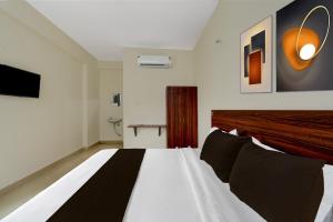 une chambre avec un lit et une télévision au mur dans l'établissement Hotel O Shabari Heights Luxury Abode AC Rooms SR Nagar Metro Station, à Hyderabad 22 autres photos