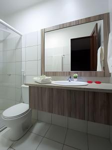 ein Badezimmer mit Waschbecken, Toilette und Spiegel in der Unterkunft Mansão14Suítes-55Pessoas-BEACH PARK - HOUSINGCEARÁ in Aquiraz + 19 Fotos