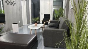 a living room with a couch and chairs and plants at Sea Urban 4 Varkiza in Vari +28 photos