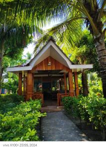 a small wooden house with a table and chairs at Blue Lagoon Resort, Neil Island in Neil Island