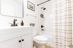 a white bathroom with a sink and a toilet at 5 Min to Adventureland and Casino - Fenced in yard in Altoona +11 photos