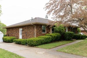 a brick house with bushes in front of it at 5 Min to Adventureland and Casino - Fenced in yard in Altoona