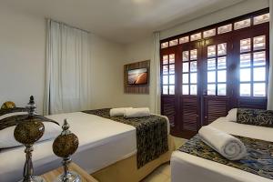 ein Hotelzimmer mit zwei Betten und einer Couch in der Unterkunft Mansão Luxo 32 Pessoas-BeachPARK - BY HousingCeara in Aquiraz