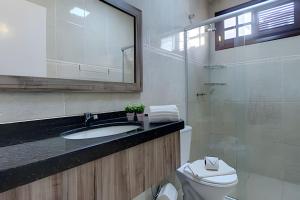ein Badezimmer mit Waschbecken, Toilette und Spiegel in der Unterkunft Mansão Luxo 32 Pessoas-BeachPARK - BY HousingCeara in Aquiraz