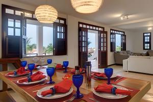 ein Esszimmer mit einem Tisch mit roten Servietten und blauen Gläsern in der Unterkunft Mansão Luxo 32 Pessoas-BeachPARK - BY HousingCeara in Aquiraz + 15 Fotos