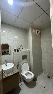 une salle de bain avec des toilettes blanches et un lavabo dans l'établissement Luxurious kaveri, à Greater Noida