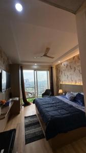 une chambre avec un grand lit et une grande fenêtre dans l'établissement Luxurious kaveri, à Greater Noida