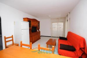 a living room with a table and a refrigerator at Edificio Esmeralda in Peniscola