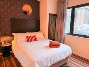 Un dormitorio con una cama con almohadas rojas. en Timeless Emporium stay with city view, en Melbourne